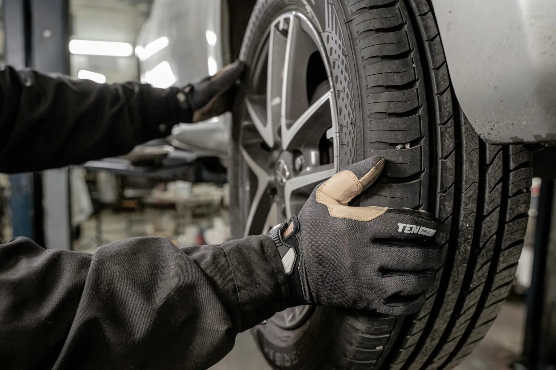 A technician checking a wheel with the vehicle raised
