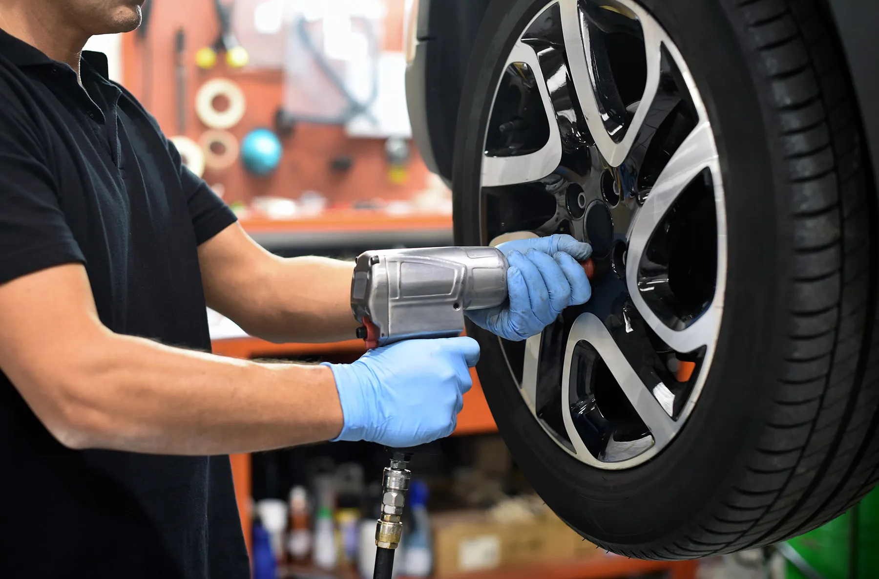 A wheel being removed with the vehicle on a two-post lift