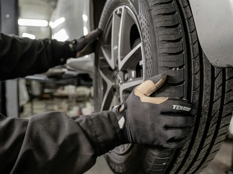 A technician checking a wheel with the vehicle raised